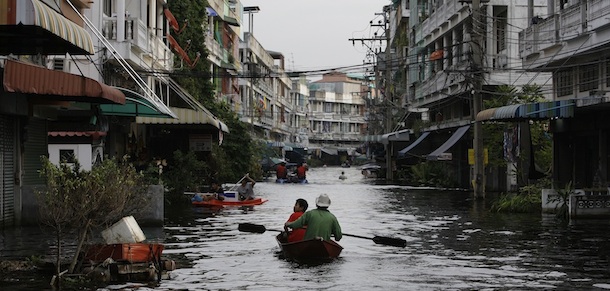 Thai residents ride boats along chest-high floods at their community in Bangkok, Thailand on Wednesday Nov. 9, 2011. The flooding began in late July and the water has reached parts of Bangkok, where residents are frustrated by government confusion over how much worse the flooding will get. (AP Photo/Aaron Favila)
