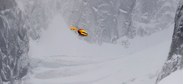 A civil rescue helicopter flies to try to locate the two climbers, a 47 year-old high-mountain guide and his client, a 44 old-year Parisian woman, who have been trapped for five nights at Pointe Walker (4.208 meters high) on the Italian side of the Grandes Jorasses mountain in the Mont Blanc massif, on November 8, 2011 in Chamonix, French Alps. AFP PHOTO / JEAN-PIERRE CLATOT (Photo credit should read JEAN-PIERRE CLATOT/AFP/Getty Images)
