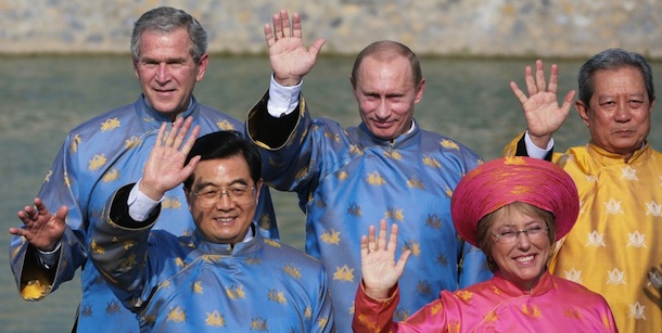 Hanoi, VIET NAM: US President George W. Bush (L), Russian President Vladimir Putin (C) Chinese President Hu Jintao (2nd L), Chilean President Michelle Bachelet (2nd R) and Thailand Prime Minister Surayud Chulanont (R), all wearing a Vietnamese &#8216;ao dai&#8217; silk tunics, take part in the official photograph for the Asian Pacific Economic Cooperation (APEC) summit in Hanoi, Vietnam 19 November 2006. AFP PHOTO/Jim WATSON (Photo credit should read JIM WATSON/AFP/Getty Images)
