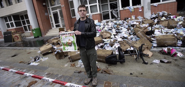 The Charlie Hebdo&#8217;s publisher, known only as Charb, shows a special edition of French satirical magazine Charlie Hebdo on November 2, 2011 in Paris, in front of the magazine&#8217;s offices which were destroyed by a petrol bomb attack overnight. The fire at the weekly magazine started around 01.00 am (0200 GMT) and caused no injuries, a police source said. Charlie Hebdo published a special edition on November 2 to mark the Arab Spring, renaming the magazine Charia (Sharia) Hebdo for the occasion, to &#8220;celebrate&#8221; the Ennahda Islamist party&#8217;s election victory in Tunisia and the transitional Libyan executive&#8217;s statement that Islamic Sharia law would be the country&#8217;s main source of law. The cover features a cartoon of the prophet, saying: &#8220;100 lashes if you don&#8217;t die of laughter!&#8221;. AFP PHOTO / ALEXANDER KLEIN (Photo credit should read ALEXANDER KLEIN/AFP/Getty Images)
