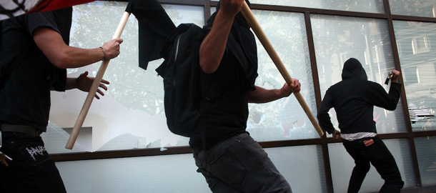 OAKLAND, CA &#8211; NOVEMBER 2: Anarchists smash the windows of a bank during an Occupy demonstration November 2, 2011 in Oakland, California. The group called for a general strike Wednesday, and planned to march on the city&#8217;s port later in the day.(Photo by Eric Thayer/Getty Images)
