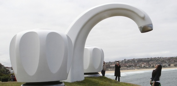 A woman prtends to wait for a drop of water while standing under Simon McGrath&#8217;s sculpture Who Left The Tap On, at Sculptures By The Sea in Sydney, Australia, Thursday, Nov. 3, 2011. Sculptures By The Sea is is the largest free-to-public outdoor sculpture exhibition spread out over a 2km coastal walk from Bondi to Tamarama beach in Sydney, featuring over 100 sculptures by artists from Australia and across the world.(AP Photo/Rob Griffith)
