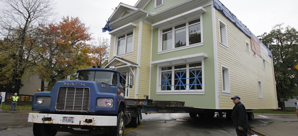 Jim Kazak, with AA House movers, keeps a close watch on the environmentally friendly house being moved Monday, Oct. 24, 2011, in Cleveland. The house was moved several blocks and was sold as a private residence. The PNC SmartHome Cleveland, completed last spring, has weather proofing features intended to save 90 percent of normal heating and cooling costs and 70 percent of total energy costs: walls 12 inches thick and triple-pane windows three to four times more efficient than most in the U.S. (AP Photo/Tony Dejak)
