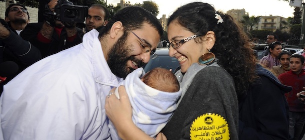 Egyptian blogger and activist Alaa Abdel Fattah is greeted by his wife Manal Hassan and their baby following his release from the police headquarters in Cairo on December 25, 2011. Egypt&#8217;s judiciary decided to free Abdel Fattah, who was remanded into custody on October 30 and who was also jailed under ousted president Hosni Mubarak, was accused of inciting violence during an October 9 demonstration by Coptic Christians. AFP PHOTO / Filippo MONTEFORTE (Photo credit should read FILIPPO MONTEFORTE/AFP/Getty Images)
