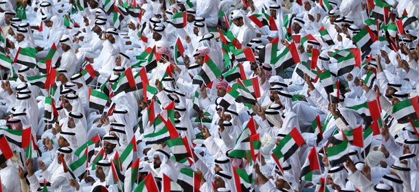 Emiratis wave national flags as citizens celerbate their countr&#8217;es 40 years of independence, on National Day in Abu Dhabi on December 2, 2011. AFP PHOTO/Karim Sahib (Photo credit should read KARIM SAHIB/AFP/Getty Images)
