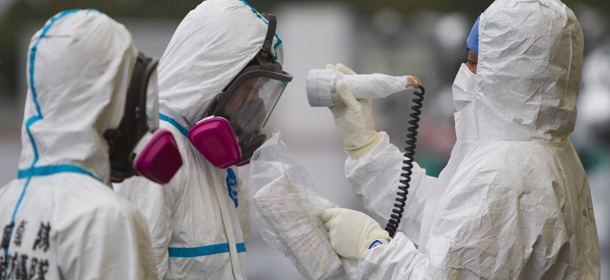 Workers dressed in protective suits and masks are checked for radiation outside a building at J-Village, a soccer training complex now serving as an operation base for those battling Japan&#8217;s nuclear disaster in Fukushima prefecture on November 11, 2011. Japan&#8217;s lower house approved a 156 billion USD draft budget to finance post quake reconstruction and boost an economy hit by slow global growth and a strong yen. AFP PHOTO / POOL DAVID GUTTENFELDER (Photo credit should read DAVID GUTTENFELDER/AFP/Getty Images)
