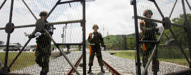 GOSEONG, REPUBLIC OF KOREA: South Korean soldiers open the gate for a North Korean train making its way through the demilitarized zone (DMZ) in Goseong, east of Seoul, 17 May 2007. Trains from North and South Korea crossed the heavily fortified border for the first time since the 1950-53 war, in what both sides described as a milestone for reconciliation. AFP PHOTO/POOL/AHN YOUNG-JOON (Photo credit should read AHN YOUNG-JOON/AFP/Getty Images)
