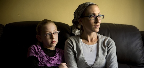 Naama Margolese, 8, sits with her mother Hadassa in their home in the central Israeli town of Beit Shemesh, Monday, Dec 26, 2011. The story of Naama Margolese, an 8-year-old American girl that has unwittingly found herself on the front line of Israel&#8217;s latest religious war, drew new attention to the religious tensions in Beit Shemesh, a city of some 100,000 just outside Jerusalem, which has become a symbol of the growing violence of Jewish extremists in Israel in recent years. (AP Photo/Oded Balilty)
