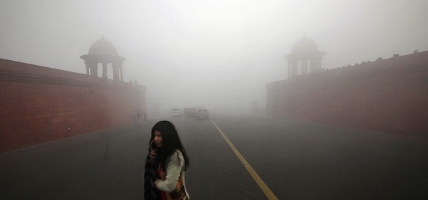 An Indian woman talks on her mobile phone as she crosses a fog enveloped road, in New Delhi, India, Monday, Dec. 19, 2011. (AP Photo/Manish Swarup)

