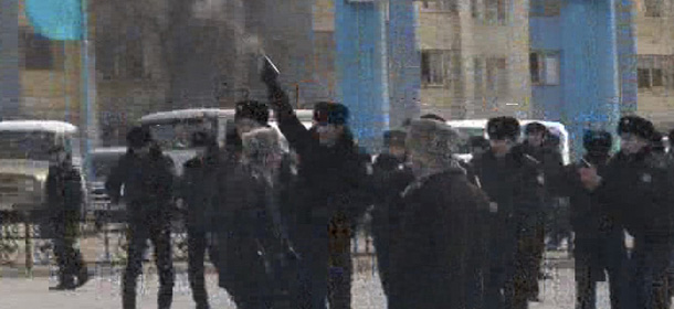 In this framegrab image from TV station K-Plus a Kazakh police officer fires a pistol to disperse demonstrators in the center of Zhanaozen, Kazakhstan, Friday, Dec. 16, 2011. Violent clashes broke out Friday between police and demonstrators in an oil town in western Kazakhstan _ the site of industrial action in recent months. One witness said police opened fire on demonstrators gathered at a meeting in the center of Zhanaozen and that at least five people have been killed and dozens injured. (AP Photo/TV Station K-Plus via AP Television News) TV OUT EDITORIAL USE ONLY
