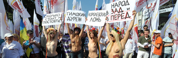 Activists of the FEMEN feminist movement hold placards on May 19, 2011 during a rally in front of the parliament in Kiev. More than 1,000 people protested in front of the Ukrainian Parliament against President Viktor Yanukovych&#8217;s unpopular economic policies. Placards read: ÒHow much does it cost to protestÓ, ÒKorolevskaÕs liesÓ, in reference to deputy Natalia Korolevska, ÒRoyal liesÓ and Òpeople in the back and frontÓ. AFP PHOTO / GENYA SAVILOV (Photo credit should read GENYA SAVILOV/AFP/Getty Images)
