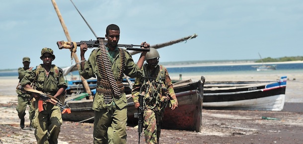 Militia allied with the Federal Government of Somalia and Kenyan Defence Force soldiers walk along the coast near Burgabo village, Southern Somalia on December 14, 2011. Burgabo is a Somalian port village which has been secured by Kenyan forces as they advance further up the Somali coastline in search of Al-Shabaab fighters. AFP PHOTO/Carl de Souza (Photo credit should read CARL DE SOUZA/AFP/Getty Images)
