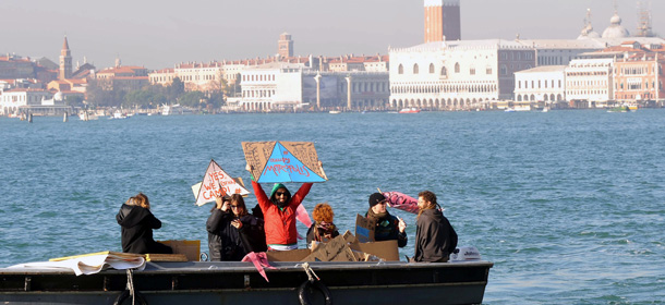 Students and demonstrators hold placards against the cuts in the education budget and against the austerity measures in Europe on November 17, 2011 in the laguna of Venice. The protesters demonstrated in front of the pavillions of several countries at the Venice Biennale of art. Italy&#8217;s new Prime Minister Mario Monti, who took office the day before, is set to unveil his economic programme, under heavy scrutiny from global leaders, financial markets and parliamentarians wary of hard-hitting reforms. Placard reads &#8220;We pay for the crisis&#8221;. AFP PHOTO / ANDREA PATTARO (Photo credit should read ANDREA PATTARO/AFP/Getty Images)
