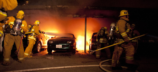 Los Angeles Fire Department firefighters extinguishes numerous cars on fire in a carport in the Sherman Oaks neighborhood of Los Angeles on Monday, Jan. 2, 2012. For the fifth night in a row, a spate of arson fires has sent firefighters scrambling to extinguish car fires in the Hollywood, Hollywood Hills, Studio City, and Sherman Oaks neighborhoods of Los Angeles. The Los Angeles Fire Department confirms a person of interest has been detained and is being questioned in connection with the arson spree. (AP Photo/Dan Steinberg)