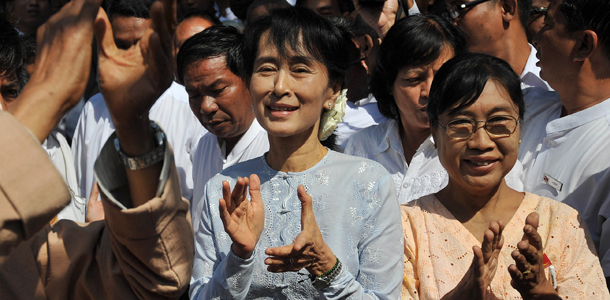 Myanmar democracy icon Aung San Suu Kyi (C) applauds during a ceremony to unveil her National League for Democracy (NLD)'s new signboard at the NLD headquarters in Yangon on January 9, 2012. Suu Kyi could be given a job in Myanmar's nominally civilian government if she is elected to parliament in April by-elections, a presidential adviser said on January 8. AFP PHOTO/Soe Than WIN (Photo credit should read Soe Than WIN/AFP/Getty Images)