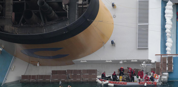 Rescuers work at the cruise ship Costa Concordia keeled over on its side in the tiny Tuscan island of Giglio, Italy, Thursday, Jan. 19, 2012. The $450 million Costa Concordia was carrying more than 4,200 passengers and crew when it slammed into well-charted rocks off the Tuscan island of Giglio. Eleven people have been confirmed dead and 21 others are still missing. (AP Photo/Gregorio Borgia)