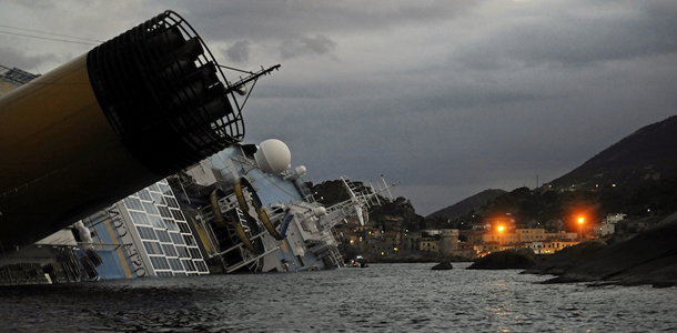The Costa Concordia cruiseship lies on January 15, 2012 in the harbor of the Tuscan island of Giglio after it ran aground and keeled over off the Isola del Giglio after hitting underwater rocks on January 13. Two South Korean honeymooners and an Italian crewman were rescued today from a cruise ship wreck in Italy but emergency services found another two bodies, bringing the death toll to five. More than a dozen people are still missing after the luxury liner, carrying more than 4,200 passengers and crew, hit rocks just off the Tuscan island of Giglio on the evening of January 13. AFP PHOTO / FILIPPO MONTEFORTE (Photo credit should read FILIPPO MONTEFORTE/AFP/Getty Images)