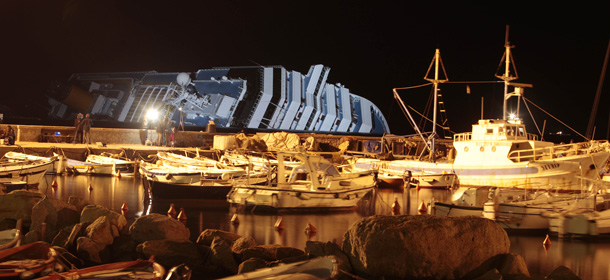 The cruise ship Costa Concordia lays on its side after running aground Friday evening on the Tuscan island of Giglio, Italy, Tuesday, Jan. 17, 2012. Five more bodies were found Tuesday in the crippled cruise ship off Tuscany, and a shocking audio recording emerged in which the ship's captain was heard making excuses as the Italian coast guard repeatedly ordered him to return on board to oversee the ship's evacuation. (AP Photo/Gregorio Borgia)