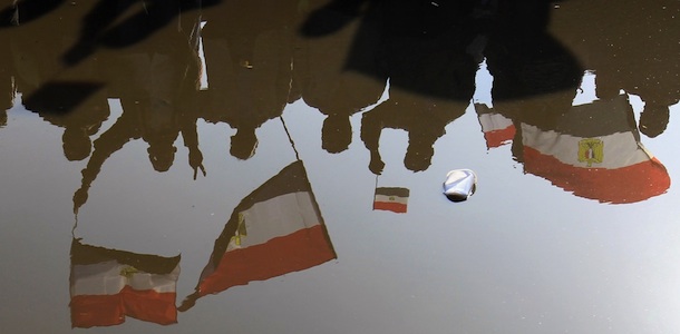 Egyptians protesters waving national flags are reflected in rain water in Cairo's Tahrir Square during a mass rally on January 25, 2012 marking the first anniversary of the uprising that toppled Hosni Mubarak, while a debate raged over whether the rally was a celebration or a second push for change. AFP PHOTO/MAHMUD HAMS (Photo credit should read MAHMUD HAMS/AFP/Getty Images)