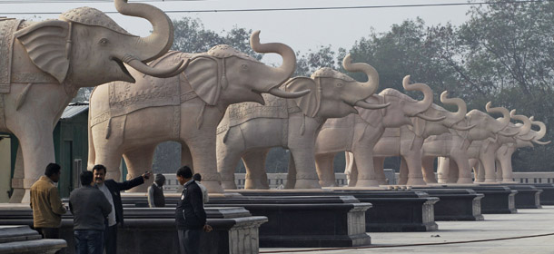 Local officials discuss their next course of action near statues of elephants at a park in Noida, Uttar Pradesh, India, Monday, Jan. 9, 2012. Workmen carting truckloads of cloth raced Monday to comply with election regulations and cover up a dozen gigantic statues that a flamboyant Indian chief minister had erected of herself. India's Election Commission said the massive statues of Mayawati, who uses one name and is a hero to the country's lowest castes, were built using public money and their display violated the rules for next month's election in her Uttar Pradesh state. (AP Photo/Saurabh Das)