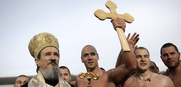 Marko Tomasevic, 31, center, lifts up a wooden cross, after being the first to reach it in a traditional cross retrieval race on the Danube river in Belgrade, Serbia, Thursday, Jan. 19, 2012. The retrieval of a cross is a traditional event that marks the Orthodox Epiphany, which according to the Julian calendar, falls on Jan. 19. (AP Photo/ Marko Drobnjakovic)