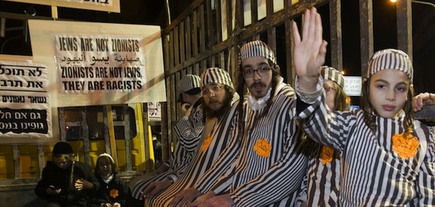 Group of ultra-Orthodox Jews wearing prison uniforms from the Holocaust and yellow Stars of David with 'Jude' written on them sit in a truck with bars during a demonstration in Jerusalem's Mea Shearim neighborhood, on December 31, 2011 to protest against what they call the 'media campaign of incitement' being waged against their community , especially as it refers to the separation of men and women in the ultra-Orthodox Jewish society. AFP PHOTO /AHMAD GHARABLI (Photo credit should read AHMAD GHARABLI/AFP/Getty Images)