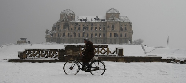An Afghan Man rides his bicycle, while Darul Aman's palace which was destroyed during the civil- war of the 1990's is seen on the background, in Kabul, Afghanistan, Thursday, Jun, 5, 2012. (AP Photo/Ahmad Jamshid)