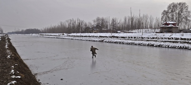 A Kashmiri youth plays on a frozen canal in Tangmarg, north of Srinagar, on January 13, 2012. Icy temperatures has frozen many bodies of water in Kashmir, as well as drinking water taps while an avalanche warning has been issued in some snowbound hilly areas. AFP PHOTO/Tauseef MUSTAFA (Photo credit should read TAUSEEF MUSTAFA/AFP/Getty Images)