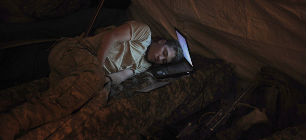 US infantryman Private Freymond Tyler of Delta Company, 2-87 Infantry Battalion, 3rd Brigade Combat Team, sleeps on his laptop next to his gun in the Delta Company barracks at combat outpost Makuan in Kandahar province in southern Afghanistan on August 13, 2011 a day before the air and ground assault mission by Delta Company against insurgents in nearby Maiwand district. According to Major Kirby Dennis, operations officer of Task Force 2-87, the August 14, 2011, five hour raid in Maiwand district resulted in the capture of eight Afghans among them are two suspected Taliban leaders and assorted bomb making components which will reduce the insurgents offensive capability in the area. AFP PHOTO / ROMEO GACAD (Photo credit should read ROMEO GACAD/AFP/Getty Images)