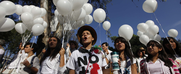Thousands of people wearing white march against gang violence in Mexico City, Sunday May 8, 2011. The group carrying signs reading "Stop the War," Mexican flags and white balloons began their march Thursday in Cuernavaca. They are expected to arrive in Mexico City's Zocalo or main plaza Sunday. (AP Photo/Eduardo Verdugo)
