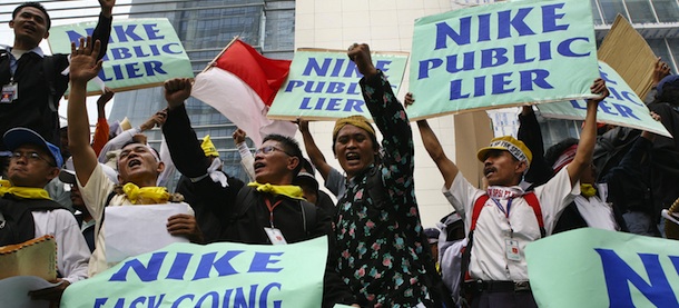 JAKARTA, INDONESIA: Indonesian workers hold posters during a demonstration outside the office of footwear maker Nike, at the Jakarta Stock Exchange (JSE) building in Jakarta, 23 July 2007. Hundreds of workers took part in the demonstration to protest against Nike's announcement to stop ordering from its two Indonesian subcontractors. Nike has announced it will stop ordering from two Indonesian subcontracting companies -- PT Hardaya Aneka Shoes Industry and Nagasakti Paramashoes Industry -- as they failed to maintain Nike's production standards and export schedules. AFP PHOTO/Ahmad ZAMRONI (Photo credit should read AHMAD ZAMRONI/AFP/Getty Images)