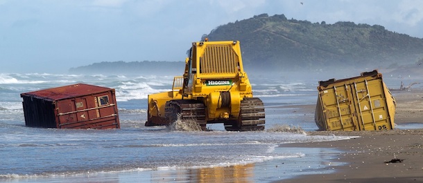 Heavy machinery moves shipping containers that have come ashore on Waihi beach in the Bay of Plenty on January 9, 2012 a day after the cargo ship Rena broke up in a storm. Shipping was also being warned away as up to 300 containers were washed from the wreck and salvage workers said on January 8 there was a strong likelihood the stern section would capsize. AFP PHOTO / Marty Melville (Photo credit should read Marty Melville/AFP/Getty Images)