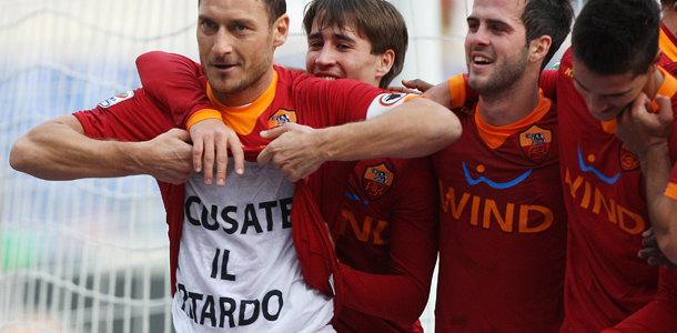 ROME, ITALY - JANUARY 08: Francesco Totti (L) of AS Roma displays the message 'scusate il ritardo' on his t-shirt as he celebrates with his team-mates after scoring a goal from the penalty spot during the Serie A match between AS Roma and AC Chievo Verona at Stadio Olimpico on January 8, 2012 in Rome, Italy. (Photo by Paolo Bruno/Getty Images)