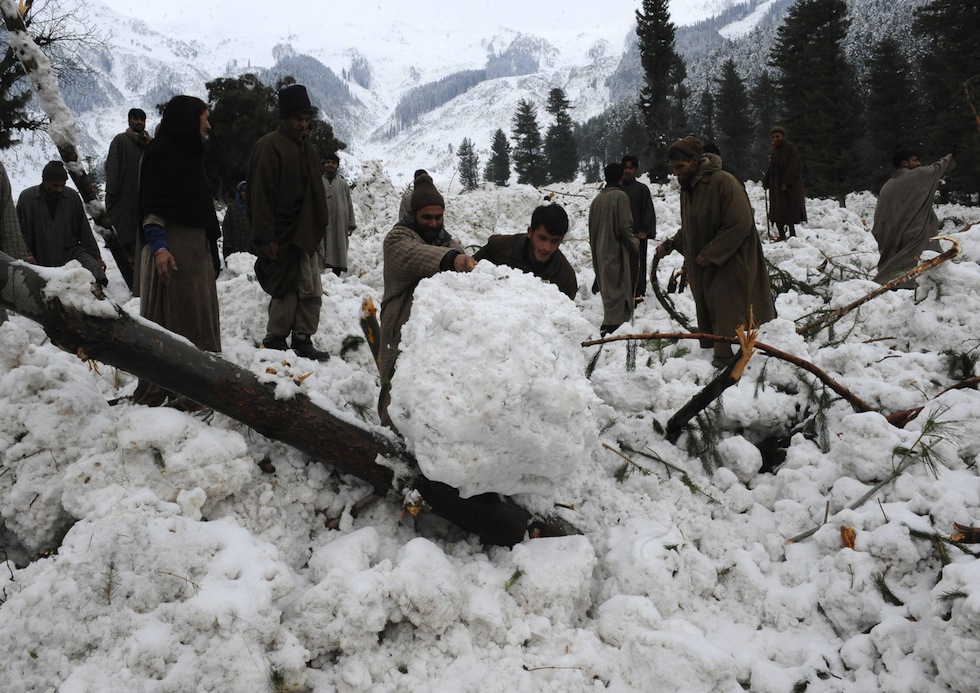 Persone cercano e loro cose sepolte da una valanga di neve a Ramwari, 23 febbraio 2012 (ROUF BHAT/AFP/Getty Images)