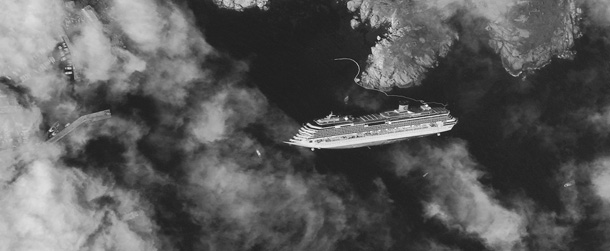This picture made available on Wednesday, Jan. 18, 2012 by DigitalGlobe, satellite image made on Tuesday, Jan. 17, 2012, shows the hulk of the luxury cruise ship Costa Concordia, which ran aground the Tuscan tiny island of Isola del Giglio, Italy, on Friday, leaning on its starboard side. As the Costa Concordia keeps shifting on its rocky ledge, many has raised the prospect of an environmental disaster if the 2,300 tonnes of fuel on the half-submerged cruise ship leaks. Satellites are used to monitor the area while authorities are preparing to remove the fuel from inside the vessel. (AP Photo/DigitalGlobe) MANDATORY CREDIT