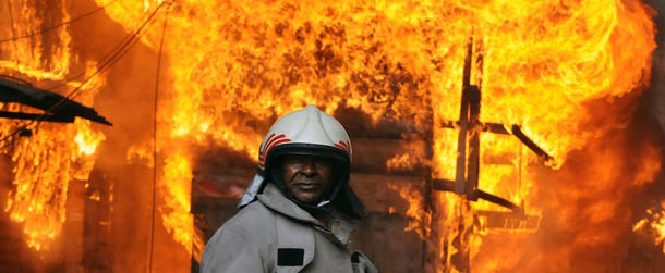A Honduran firefighter stands in front of the blazing Colon and San Isidro markets, in Tegucigalpa, on February 18, 2012. (Photo credit should read ORLANDO SIERRA/AFP/Getty Images)