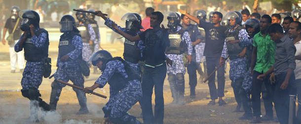 Maldives police officers throw tear gas canisters during a clash with the military in Male, Maldives, Tuesday, Feb. 7, 2012. The first democratically elected president Mohamed Nasheed of Maldives resigned Tuesday after police joined the protesters and then clashed with soldiers amid protests over his controversial arrest of a top judge. (AP Photo/Sinan Hussain)