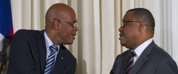 FILE - In this Oct. 6, 2011 file photo, Haiti's President Michel Martelly, left, shakes hands with his new Prime Minister Garry Conille during a press conference in Port-au-Prince, Thursday Oct. 6, 2011. For many Haitians who remember the brutal rule of Haiti's ex-dictator Jean-Claude "Baby Doc" Duvalier, the rise of his loyalists to the new president's inner circle triggers suspicions about where Martelly's loyalties lie. Martelly tapped the children of Duvalier officials, including Prime Minister Garry Conille, a former chief of staff to Bill Clinton in the ex-president's role as U.N. special envoy to Haiti. Conille's father, Serge, was a minister of sports and youth for the dictatorship. (AP Photo/Dieu Nalio Chery, File)