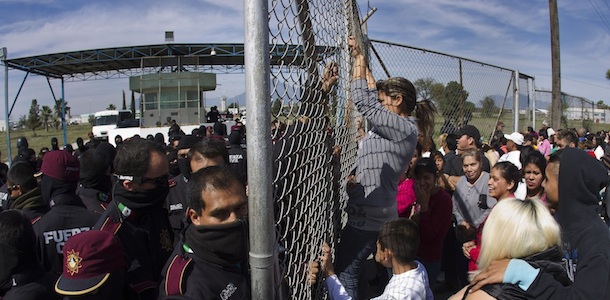 Police hold back the relatives of inmates outside Apodaca correctional state facility as they try to get past the gates in Apodaca on the outskirts of Monterrey, Mexico, Sunday Feb. 19, 2012. A fight among inmates at the prison led to a riot that killed dozens on Sunday, according to a security official. (AP Photo/Hand Maximo Musielik)