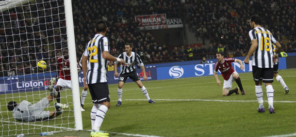 Juventus goalkeeper Gianluigi Buffon saves on AC Milan's Sulley Muntari during a Serie A soccer match between AC Milan and Juventus, at the San Siro stadium in Milan, Italy, Saturday, Feb.25, 2012. (AP Photo/Luca Bruno)