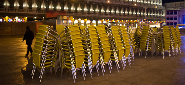 A man walks past chairs at St Mark's square (Piazza San Marco) during the carnival in Venice, late on February 11, 2012. The 2012 edition of the Venice Carnival runs from February 4 to February 21 and is entitled âLife is theatre! Itâs time to get a maskâ. AFP PHOTO / LAURENT KALFALA (Photo credit should read LAURENT KALFALA/AFP/Getty Images)