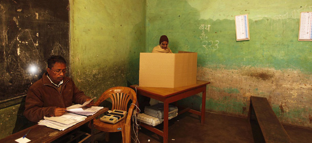 An elderly Indian stands in front of an electronic voting machine to cast his vote inside a polling station in Varanasi, India, Wednesday, Feb. 15, 2012. The third phase of the seven-phased elections in Uttar Pradesh, India's most populous and politically crucial state, is being held Wednesday. (AP Photo/Rajesh Kumar Singh)
