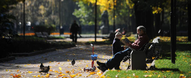A man reads a book as he plays with a kid at the boulevard in Moscow on October 5, 2010. AFP PHOTO / DMITRY KOSTYUKOV (Photo credit should read DMITRY KOSTYUKOV/AFP/Getty Images)