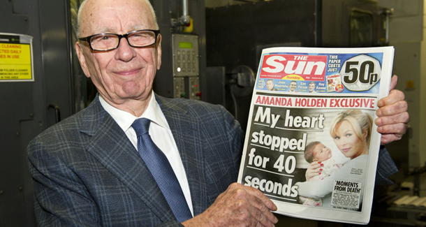 In this photo provided by News International (NI Group Ltd.) taken on Saturday Feb. 25, 2012, News Corporation Chairman and CEO Rupert Murdoch holds the first edition of The Sun on Sunday as it comes off the presses at Broxbourne, England. (AP Photo/Arthur Edwards)