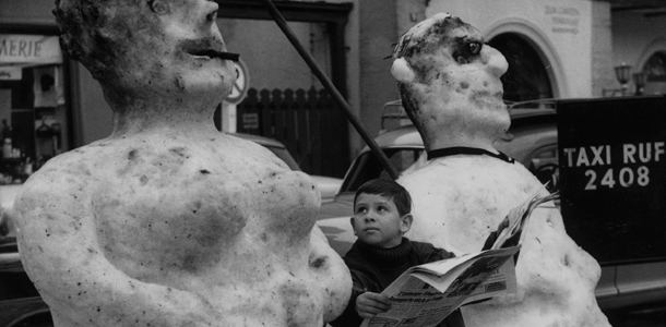 24th January 1966: A boy sitting between a giant snowman and snowwoman in a street in Garmisch-Partenkirchen, Bavaria. (Photo by Keystone/Getty Images)