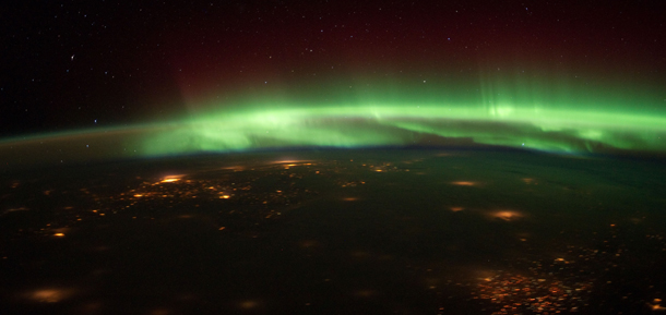 This image provided by NASA shows the Aurora Borealis in this nighttime photograph shot from the International Space Station as the orbital outpost flew over the Midwest recently. Cloud cover makes it difficult to identify the cities that are within the captured area. The spacecraft was above south central Nebraska when the photo was taken. The "look" angle is north to northeastward. (AP Photo/NASA)