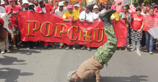 A demonstrator performs tricks as he takes part in a march in Johannesburg Wednesday, March 7, 2012 to protest against planned road tolls in the Johannesburg area and to call for the government to ban companies that supply temporary workers with employment. (AP Photo/Lungelo Mbulwana)