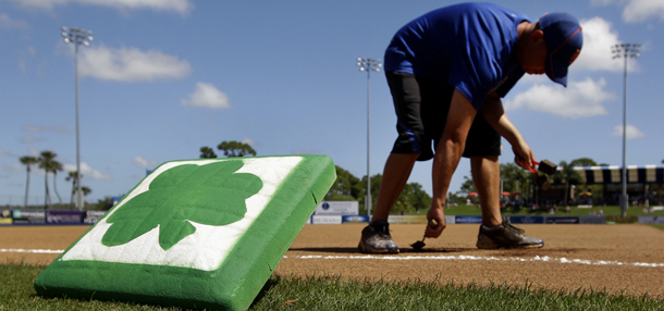 Groundskeeper Larry Mahr prepares to place third base before a spring training baseball game between the Atlanta Braves and the New York Mets in Port St. Lucie, Fla., Saturday, March 17, 2012. (AP Photo/Patrick Semansky)