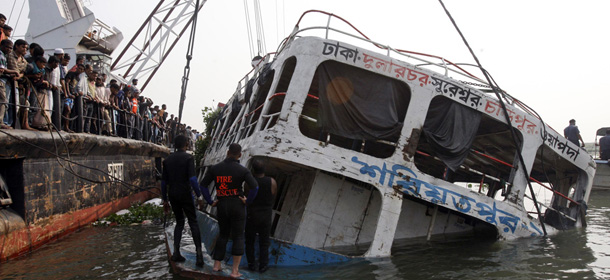 A crane lifts the wreckage of a ferry that capsized in the Meghna River in Munshiganj district, about 32 kilometers (20 miles) south of Dhaka, Bangladesh, Wednesday, March 14, 2012. Recovery workers were trying to raise the wreckage of a ferry that capsized on a river in Bangladesh while carrying about 200 people, hoping Wednesday's efforts would reveal the fate of dozens of passengers still missing. The death toll rose to 110, while dozens of passengers still remain missing. (AP Photo/Pavel Rahman)