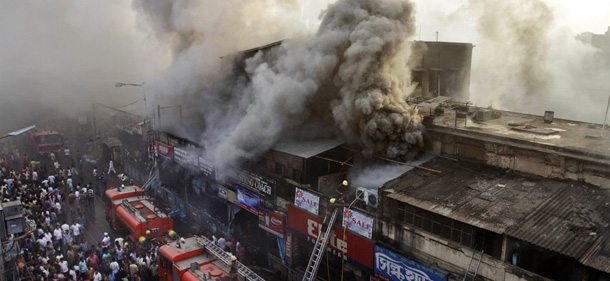 Indian firefighters work to extinguish a fire as smoke billows from a market building in Kolkata, India, Thursday, March 22, 2012. A large number of shops at the Hatibagan market, one of the oldest in the metropolis, were reduced to ashes in a devastating blaze that broke out in early Thursday morning. No casualties have been reported so far. (AP Photo/Bikas Das)
